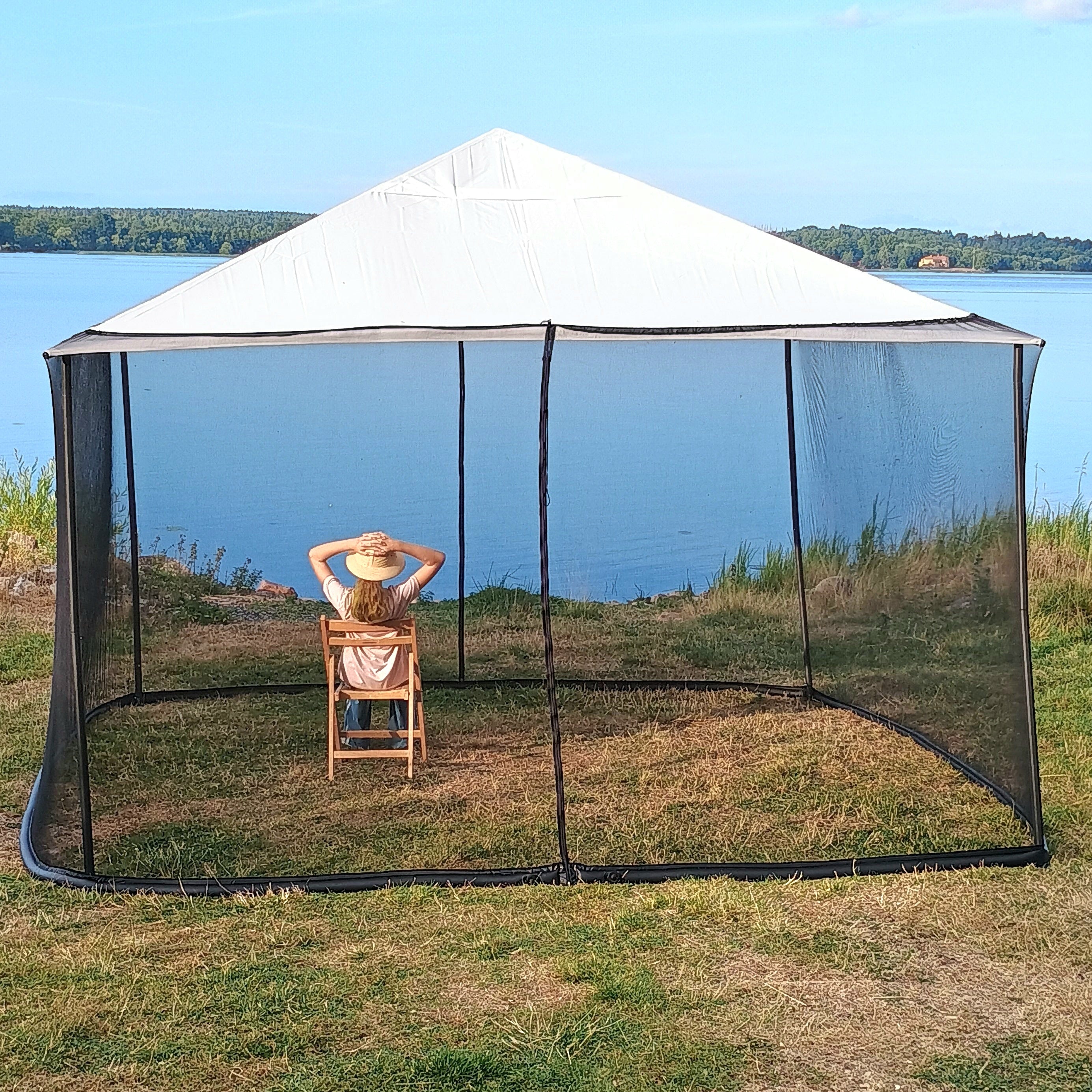 Woman showing the height of a black 250 × 1650 cm mosquito net installed on a 4 × 4 m square gazebo