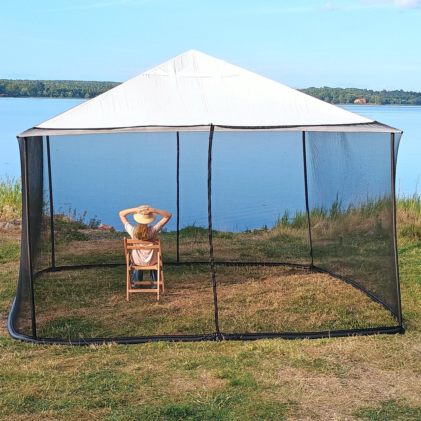 Woman showing the height of a black 250 × 1650 cm mosquito net installed on a 4 × 4 m square gazebo