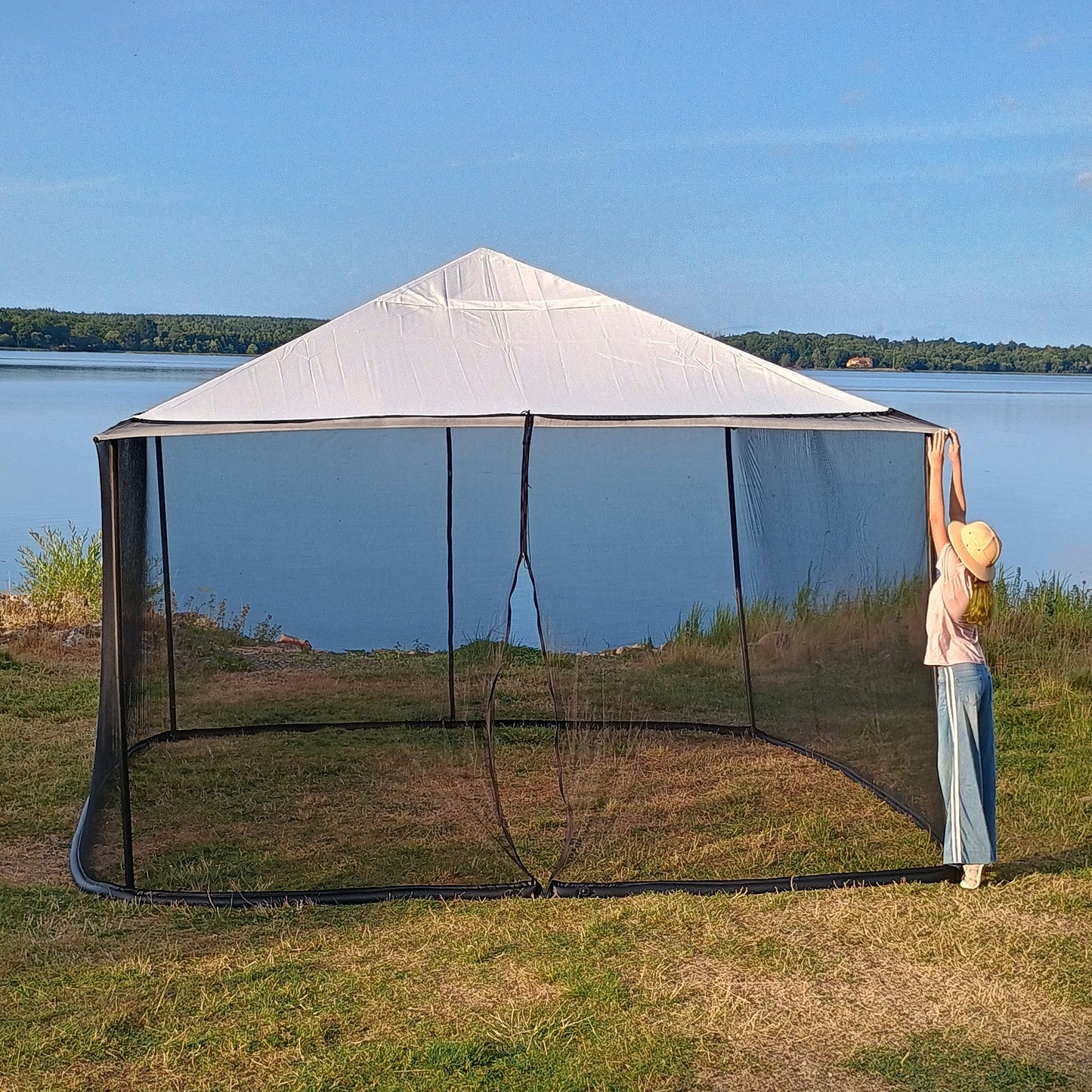 Woman checking the upper corner of a 250 × 1650 cm black mosquito net installed on a 4 × 4 m square gazebo