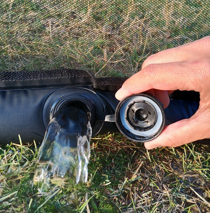 Water draining from the open fill cap of a mosquito-net lower tube before storage