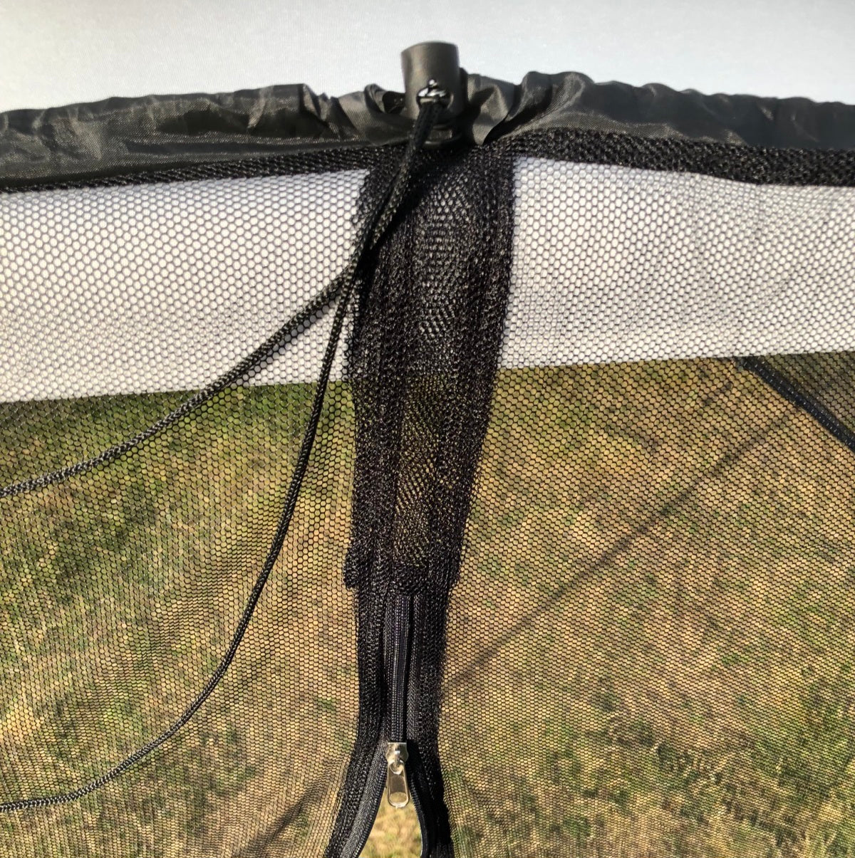 Close-up of a zipper opening above the integrated water-fill tube of the mosquito net 