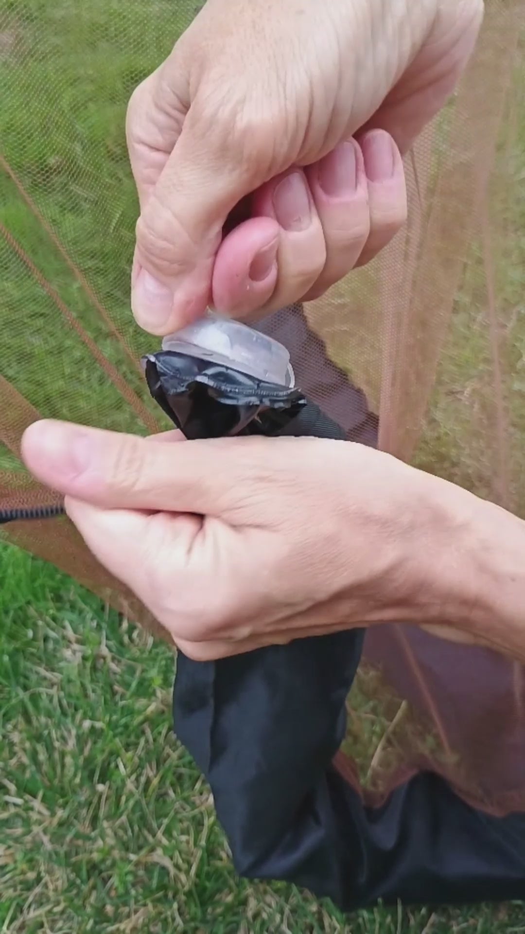 Video comparing a tight standard mosquito-net water-tube cap opened with pliers and the redesigned HousesNice cap opened by hand.